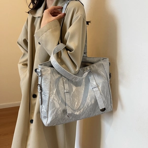 Macro detail of high-quality silver metallic crinkled tote bag with dual straps