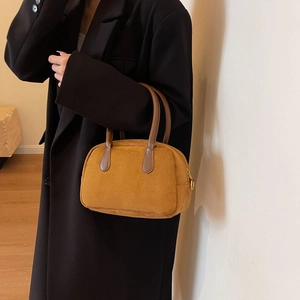 Detailed view of caramel suede bowling bag with contrast dark brown leather handles
