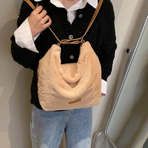 Détail d'un sac bandoulière en fausse fourrure abricot avec patch en cuir et bandoulière