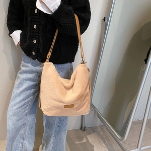 Détail du sac à épaule en peluche beige avec texture en fausse fourrure et anses en cuir