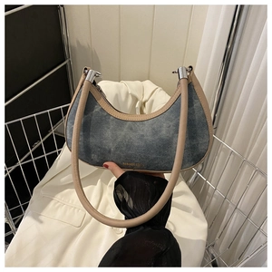 Detail of vintage denim crescent bag with faux leather strap and silver hardware