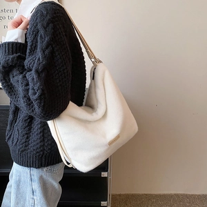 Sac fourre-tout minimaliste en fausse fourrure blanche avec logo doré et bandoulière en chaîne