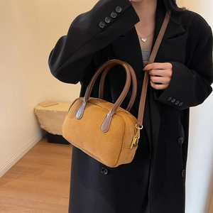 Detail of vintage brown suede mini Boston bag with adjustable leather shoulder strap on model