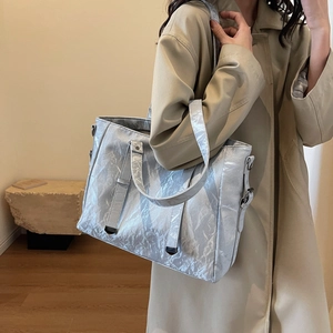 Detail of silver metallic tote bag with pleated texture and stylish shoulder strap