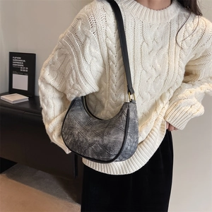 Détail du sac croissant en denim gris délavé avec bandoulière en cuir noir chic