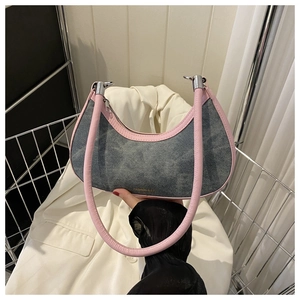 Detail of blue denim crescent bag with pink leather trim and silver metal hardware