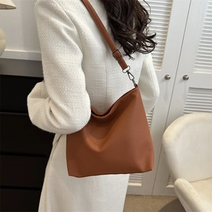 Detail of hobo bag with brown lychee texture leather and adjustable shoulder strap