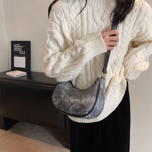 Vue détaillée d'un sac hobo gris avec texture denim et bandoulière en cuir noir