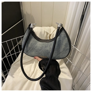 Detail of crescent moon shoulder bag with denim texture and faux leather trim