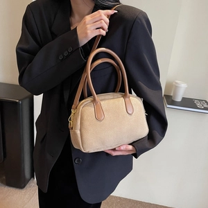 Close-up of minimalist beige PU leather shoulder bag featuring brown handles and gold buckle