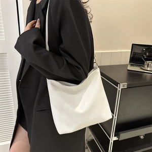 White faux leather tote bag with lychee texture shown on model in professional setting