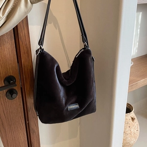 Sac à épaule minimaliste en peluche noire avec étiquette et fines lanières