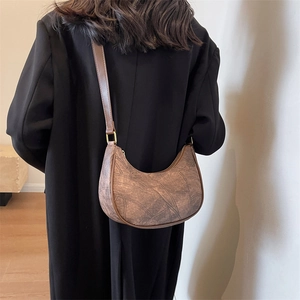 Sac à bandoulière demi-lune marron minimaliste avec texture cuir vintage et détails dorés