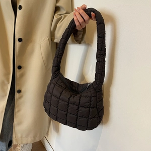 Detail of black quilted bubble handbag with puff texture and silver zipper closure