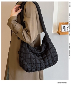 Detailed view of a black quilted bubble hobo bag with a stylish wide shoulder strap