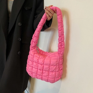 Detail of hot pink puffer tote bag showing quilted nylon texture and padded shoulder strap