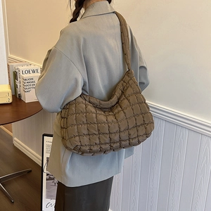 Deep brown quilted puffer underarm bag showing large capacity and soft fabric texture