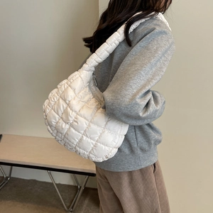 White quilted bubble underarm bag with soft nylon texture shown on a female model