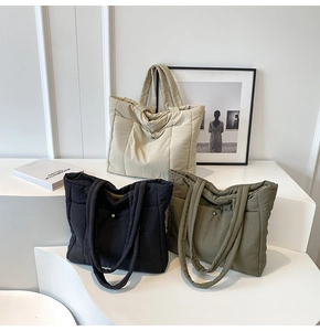 Close-up of quilted down tote bags in black, beige, and olive with soft fabric texture