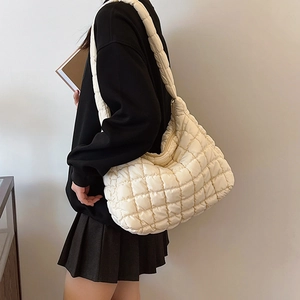Chic white quilted crossbody puffer bag shown as a side view on a model