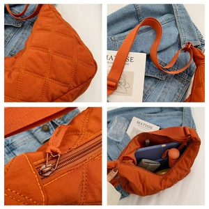 Leuchtend orangefarbene gesteppte Schultertasche mit Rautenmuster und verstellbarem Gurt