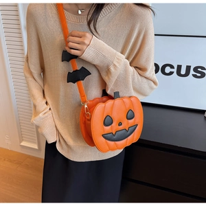 Detail of pumpkin crossbody bag featuring black bat charms and festive jack-o-lantern face