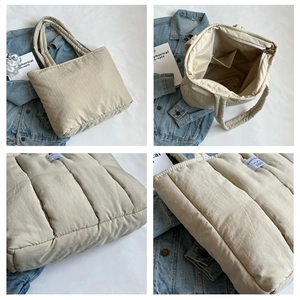 Detail of quilted tote bag featuring a metal zipper closure and spacious interior pockets
