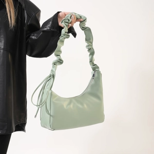 Détail du sac sous le bras en PU vert menthe avec bandoulière plissée élégante