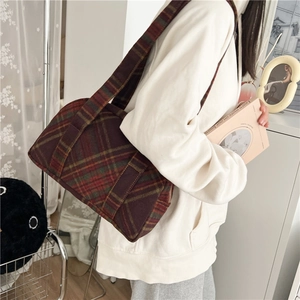 Detail of vintage brown plaid wool shoulder bag featuring classic Scottish tartan texture