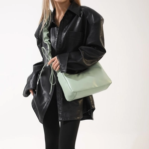Gros plan d'un sac en cuir PU vert menthe avec bandoulière à volants sur mannequin