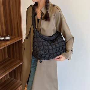 Close-up of black quilted puffer fabric texture on a stylish underarm cloud bag for women
