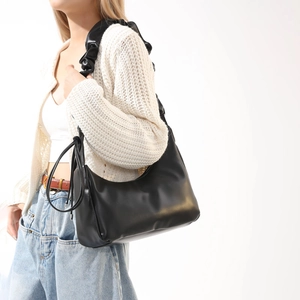 Détail d'un sac hobo noir en cuir PU avec une bandoulière froncée au design élégant