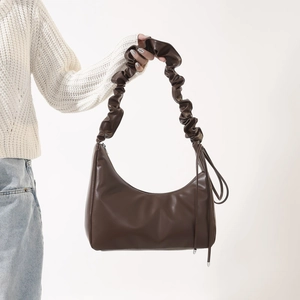 Détail du sac hobo croissant marron foncé avec bandoulière plissée en forme de nuage
