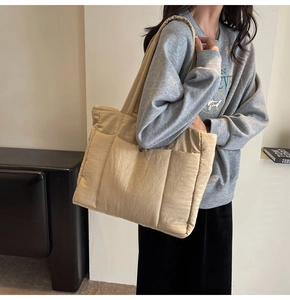 Close-up of lightweight quilted tote bag in light camel showing plush texture and strap
