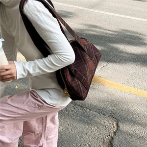 Detail of vintage plaid wool shoulder bag featuring brass zipper and classic check pattern