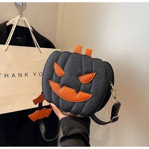 Detail of Jack-o'-lantern crossbody bag with bat charms and textured black leather finish