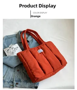 Detail of quilted orange down tote bag with peach tree label and soft padded handles