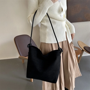Minimalistische schwarze Wildleder-Beuteltasche mit Knotendetail am Trageriemen am Model