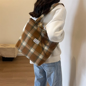 Detail view of winter plaid wool tote bag styled on model with soft minimalist interior