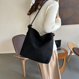 Große schwarze Wildleder-Einkaufstasche am Model für einen minimalistischen Büro-Stil