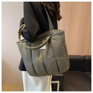 Detail of olive green quilted tote bag showing large capacity and soft padded texture