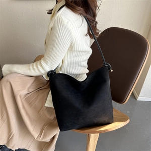 Detailansicht einer schwarzen Hobo-Tasche aus Wildleder mit geknoteten Lederriemen