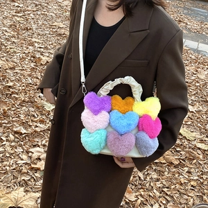Détail de cœurs en peluche colorés sur un sac beige avec poignée nuage froncée