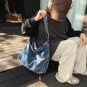 Primo piano all'aperto di una borsa tote in denim vintage con ampia tracolla e cuciture