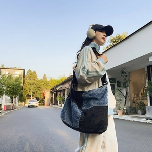 Vista dettagliata della borsa a tracolla in denim patchwork con tessuto blu e nero casual