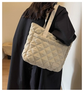 Detailansicht der cremefarbenen Stepptasche mit Rautensteppung und breitem Schultergurt
