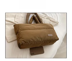 Sac fourre-tout matelassé marron avec un smartphone pour comparer la taille et l'échelle