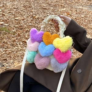 Gros plan d'un sac en toile blanche orné de cœurs en peluche colorés dans un décor d'automne