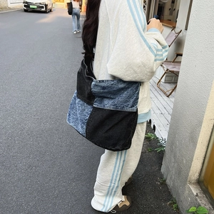 Dettaglio del motivo patchwork denim blu e nero su una grande borsa a tracolla morbida