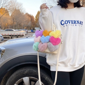 Détail du sac bandoulière en toile blanche avec cœurs en peluche 3D colorés et sangle réglable